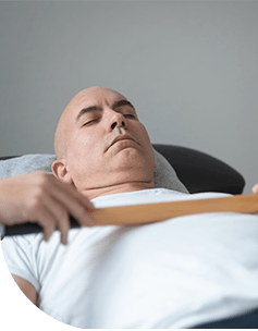 Mann in meditativer Haltung mit geschlossenen Augen, verbunden mit Sensoren, die seine Herzrate messen, in einer entspannenden Umgebung.